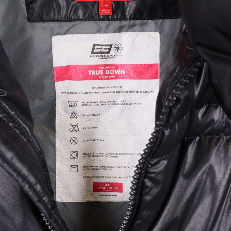 Inneretikett med skötselråd och True Down information i svart väst