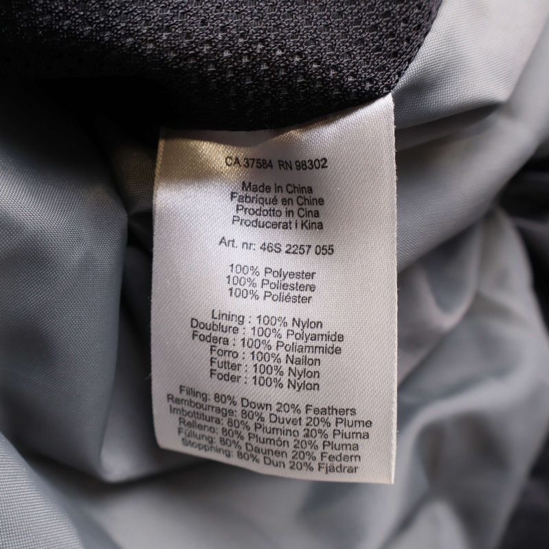 Materiallapp som visar sammansättning och material procent i svart väst