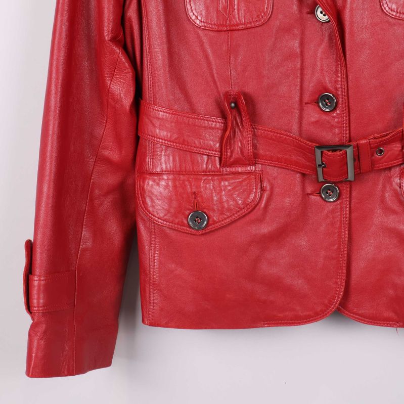 Närbild på nederdelen av röd skinnjacka, bälte och ficka