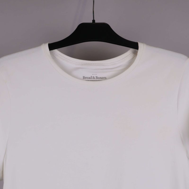 Närbild på halsringning framtill på vit t-shirt