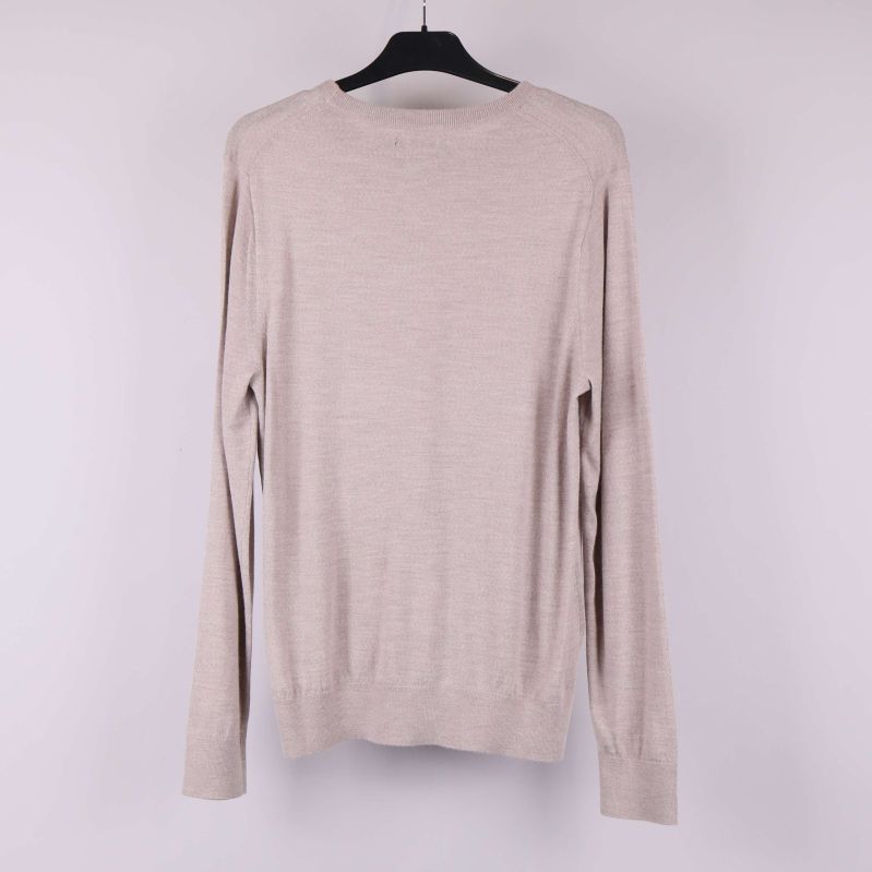 Beige långärmad tröja bakifrån på galge