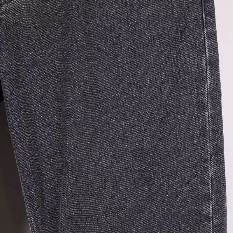 Närbild på benets material och textur på svarta jeans