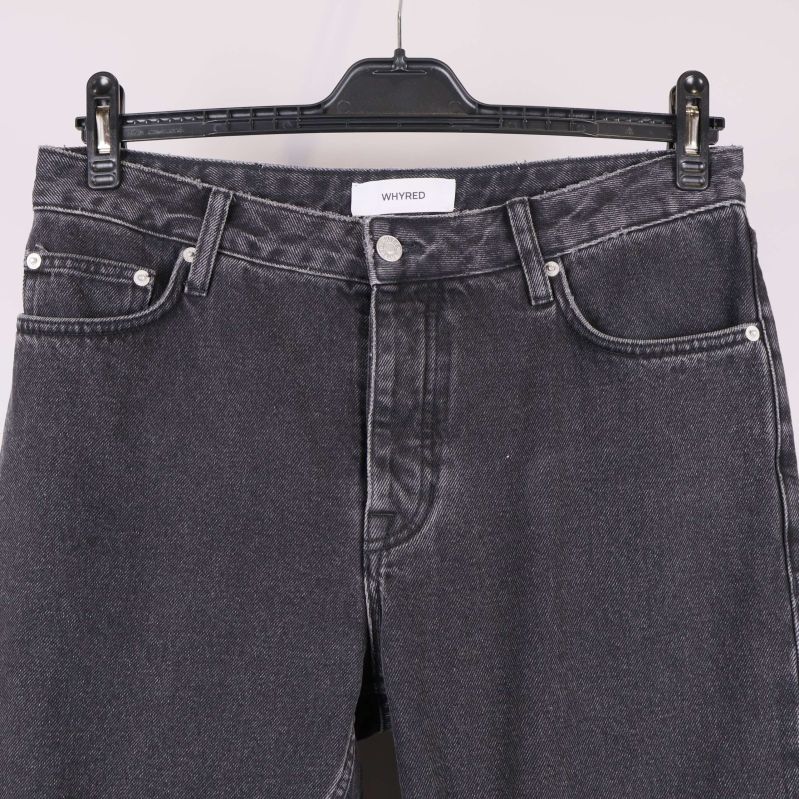 Närbild på midja och fickor av svarta jeans