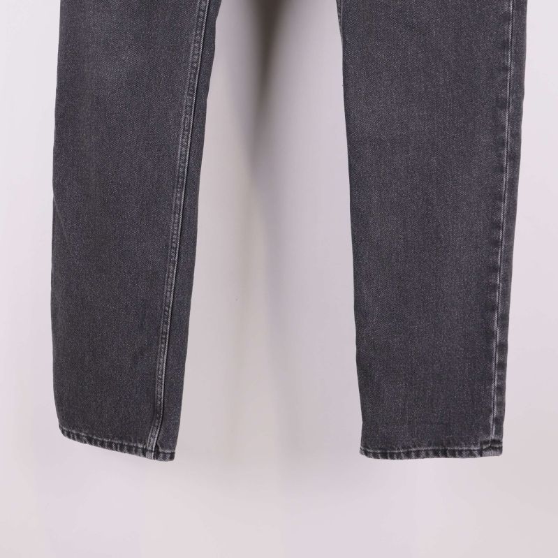 Närbild på benslut och sömmar av svarta jeans