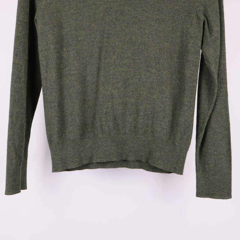 Nedre delen av grön tröja och ärmfåll