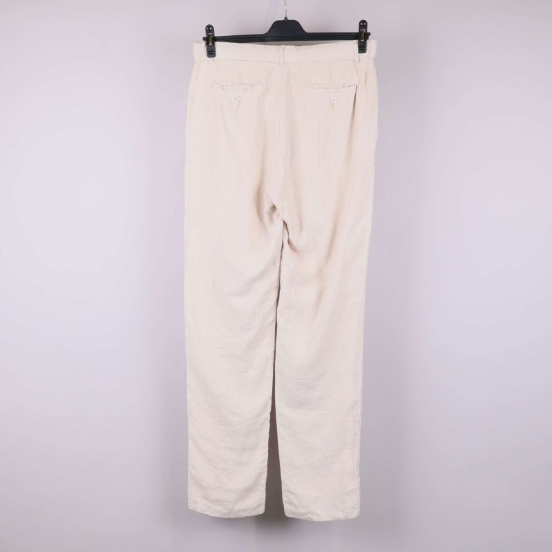 Ljusbeiga linnebyxor upphängda bakifrån