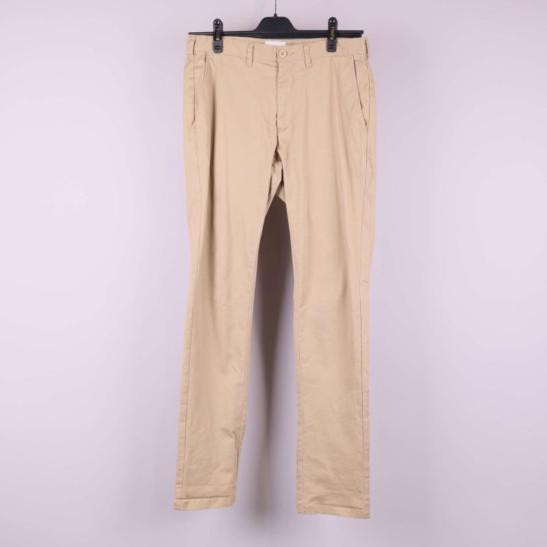 Beiga byxor med raka ben framifrån på galge