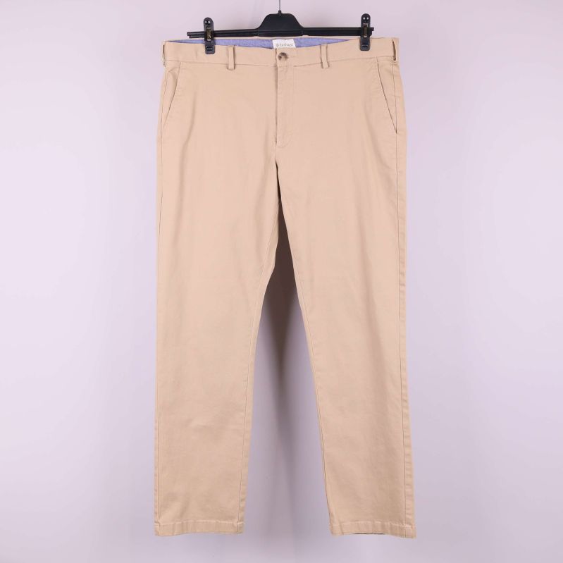 Beiga raka byxor upphängda mot ljus bakgrund