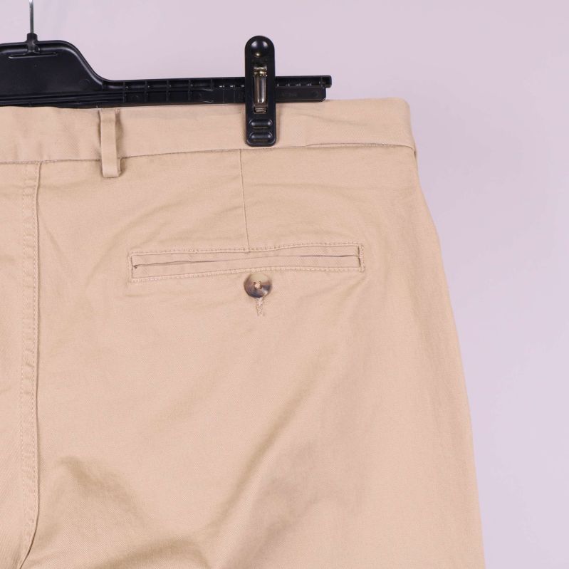 Bakficka med knapp på beigea byxor