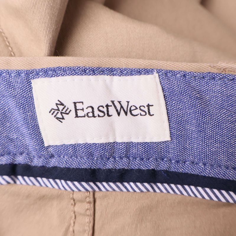 Närbild på vit EastWest-logga på blå tygpanel