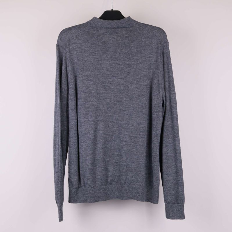 Baksida av grå långärmad polotröja på galge