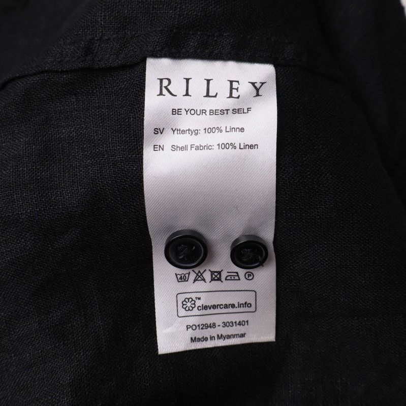 Materialetikett som visar 100% linne och reservknappar