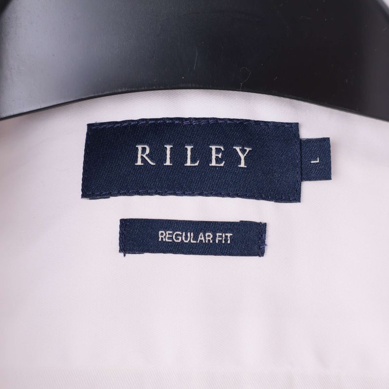 Närbild av RILEY-logga och storleksetikett i krage