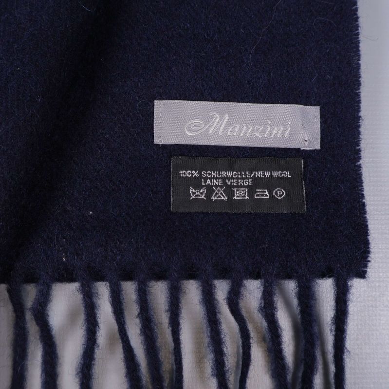 Närbild på Manzini etikett och ullmaterial