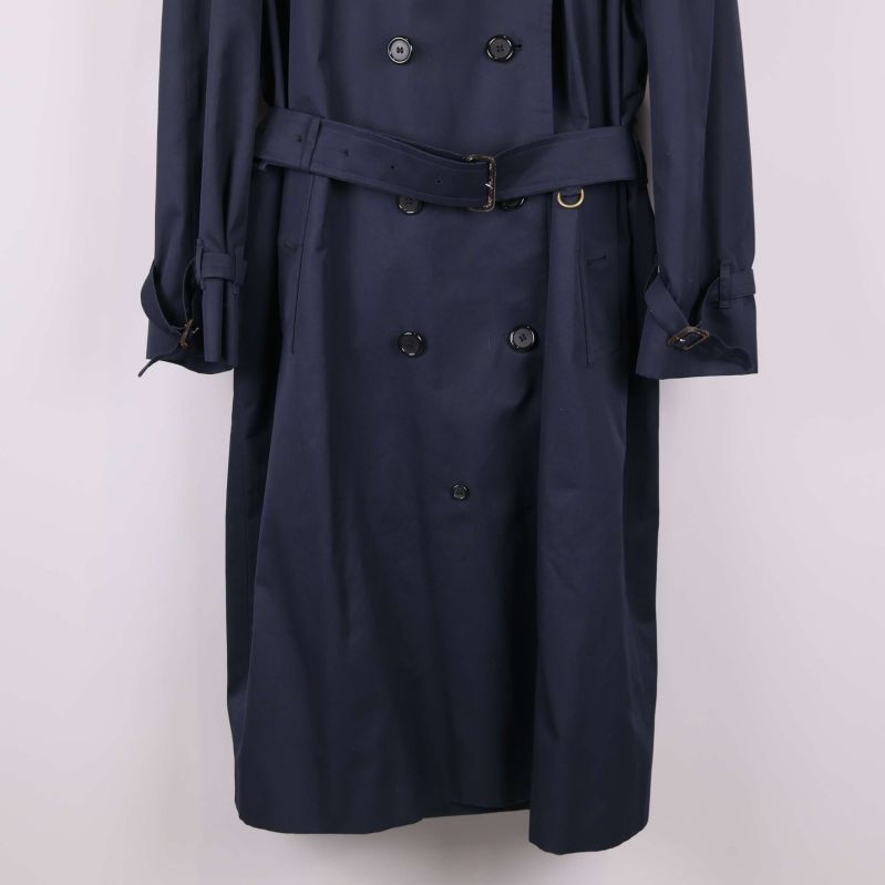 Närbild på trenchcoatens bälte och knäppning framtill