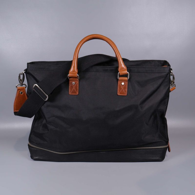 Baksidan av svart weekendbag med läderhandtag och axelrem
