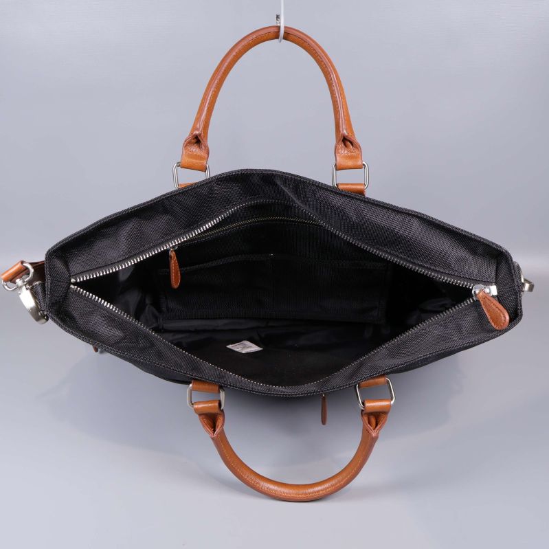 Öppen svart weekendbag med rymligt fack och bruna handtag