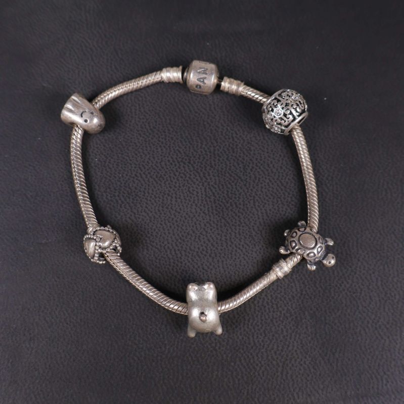 Charmarmband i silverfärg med olika pärlor uppifrån