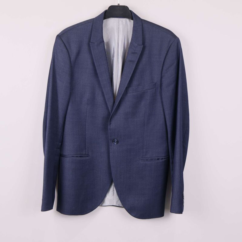 Helblå kostymkavaj hänger mot ljus bakgrund