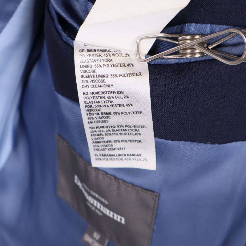 Materialetikett i kavaj visar ull och polyesterblandning