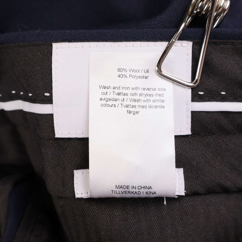 Materialetikett: 60% ull, 40% polyester, och skötselråd