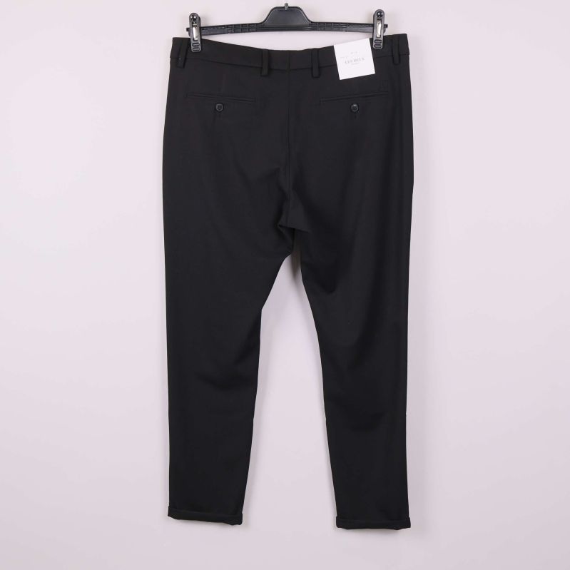 Baksidan av svarta kostymbyxor med bakfickor och hällor