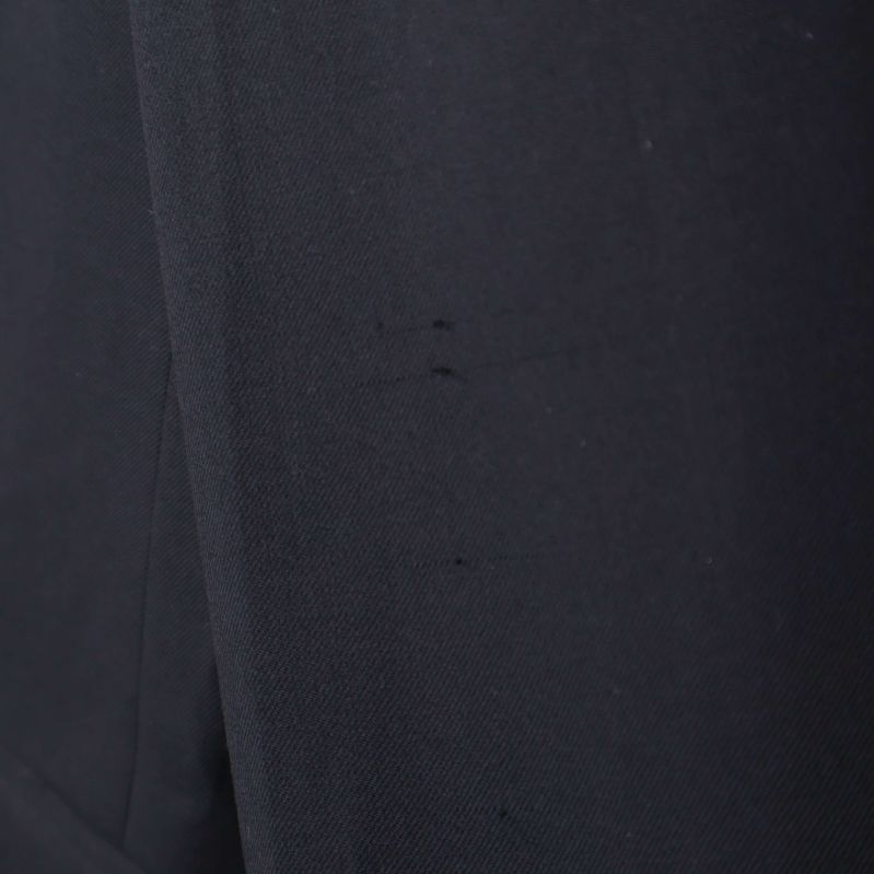 Närbild på svarta märken eller tråd på kavajtyg