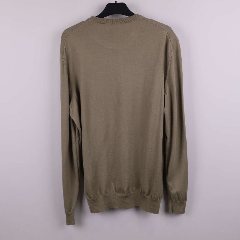 Baksidan av beige stickad tröja visas