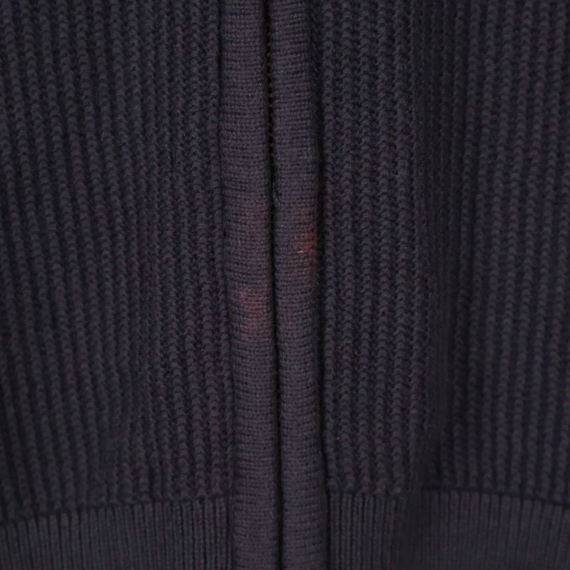 Närbild på lätt röd missfärgning vid dragkedjans nederkant