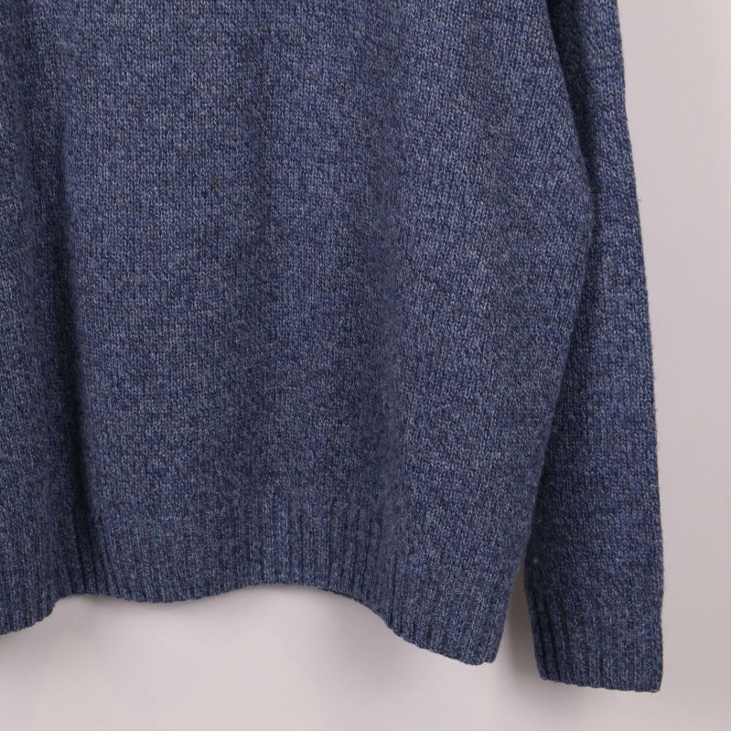 Närbild på blå stickad tröjans nederdel och struktur