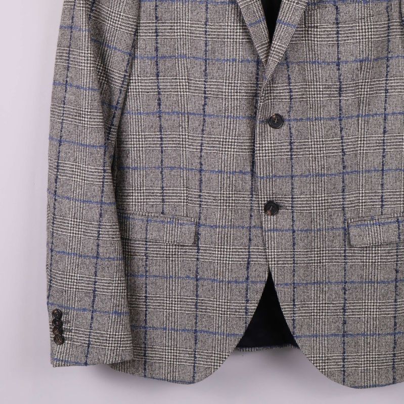 Närbild på blazer med framficka och knappar