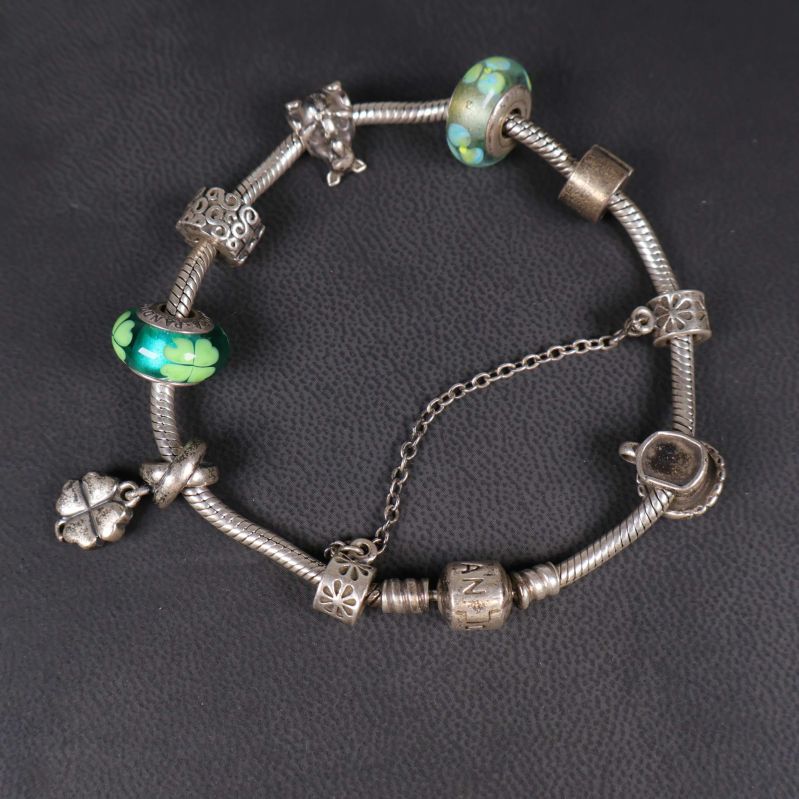 Baksidan av armbandet med synliga berlocker och gröna pärlor