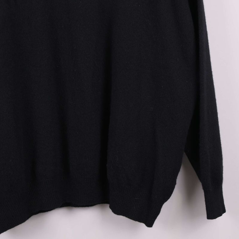 Närbild på nederkant och ärm av svart tröja