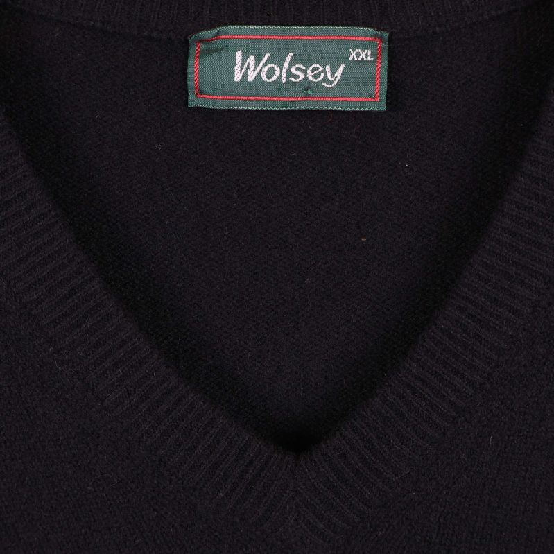 Närbild av grönt Wolsey-märke i nacken på tröjan