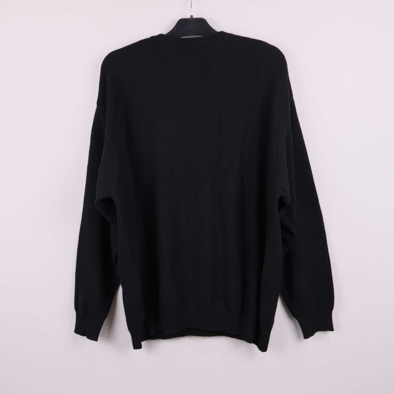 Baksidan av svart tröja visas upphängt på galge