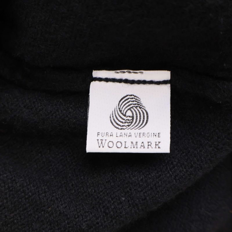 Materiallapp med Woolmark och text pura lana vergine