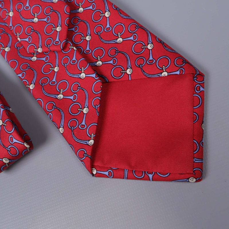 Detaljbild på röd slips med slät ena spets