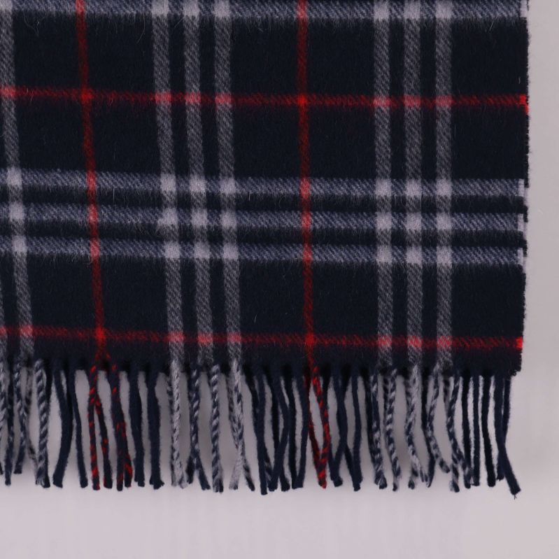 Närbild på halsdukens fransar och rutigt mönster