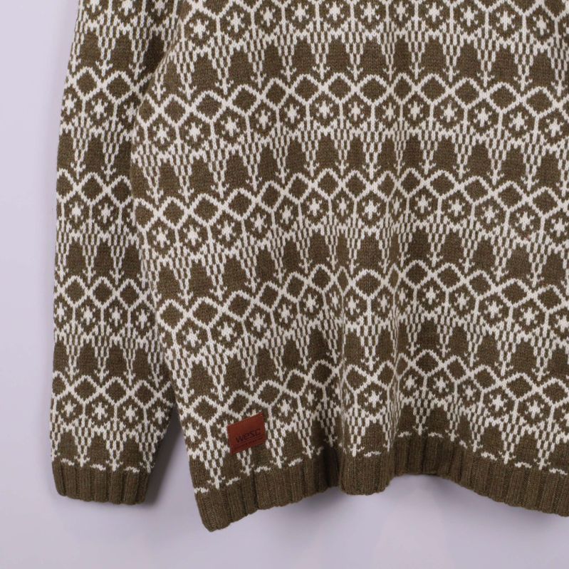 Närbild på nederkant av tröjan och etikett på brunt läder