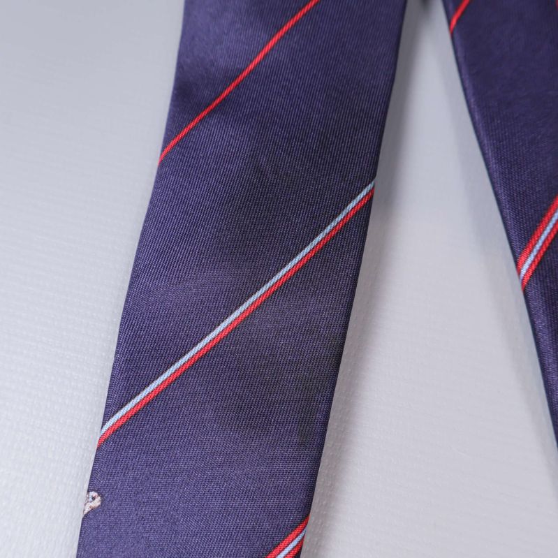 Närbild av slipsens lila tyg med röd rand