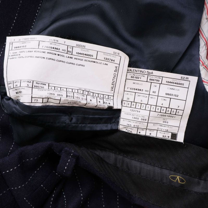 Material- och produktionsetiketter insydda i kostymens foder