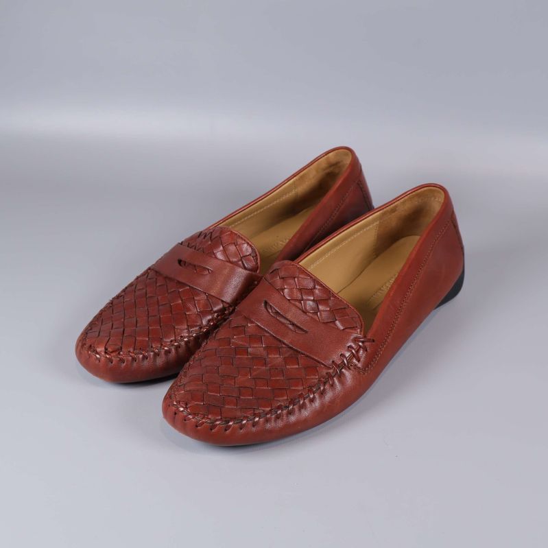 Par bruna loafers med flätad ovandel fotade snett framifrån