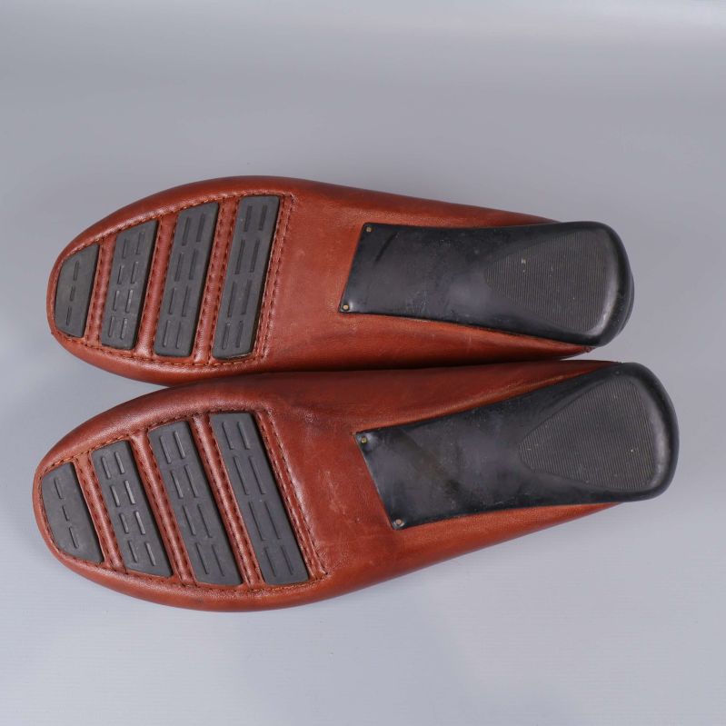 Undersidan av loafers med svarta gummipartier på sulan