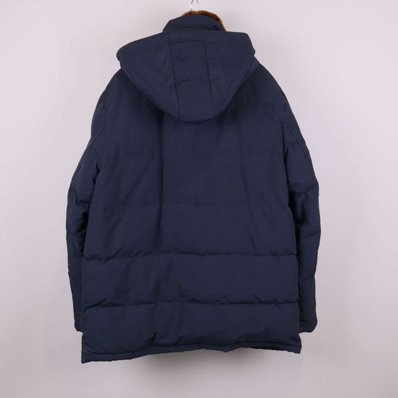 Baksida av mörk jacka med huva mot vit bakgrund