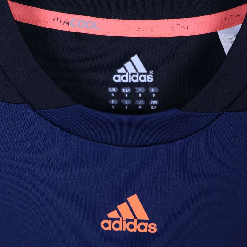 Närbild av Adidaslogga och Infinitex-märkning i kragen