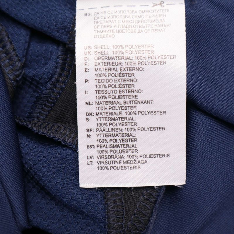 Etikett som visar materialet 100% polyester på flera språk