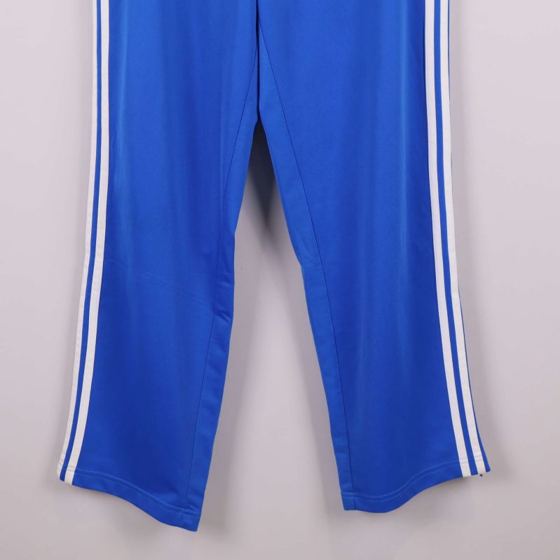 Närbild på benslut och sidoremsor på blå byxa