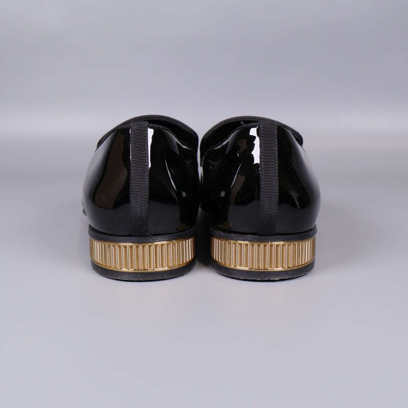 Baksidan av loafers visar guldfärgad randig detalj