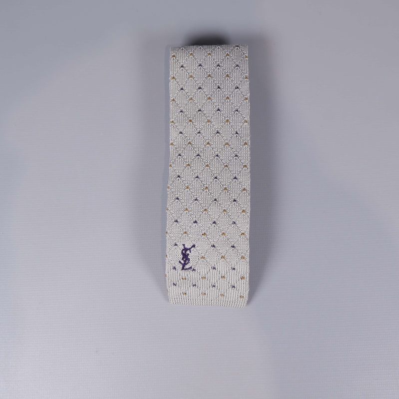 Stickad slips med diskret prickigt mönster och lila logga