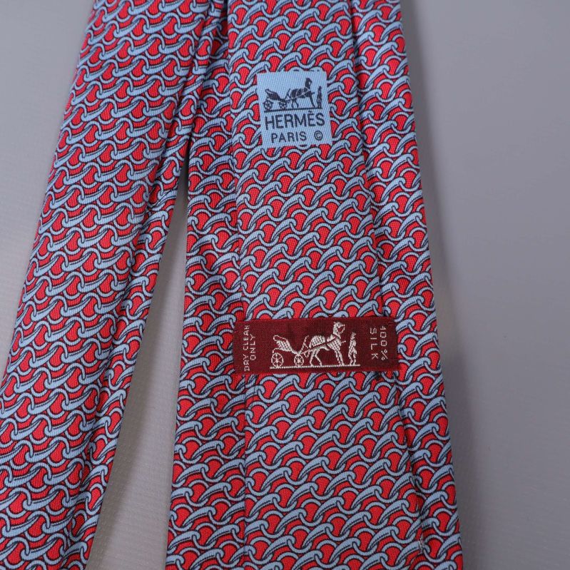 Närbild på Hermès-etikett och mönster på slips
